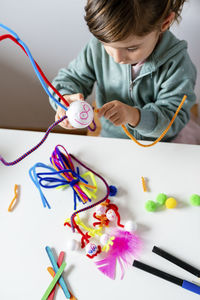 High angle view of boy holding toy on table