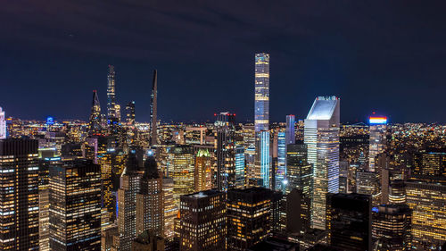 Illuminated cityscape against sky at night