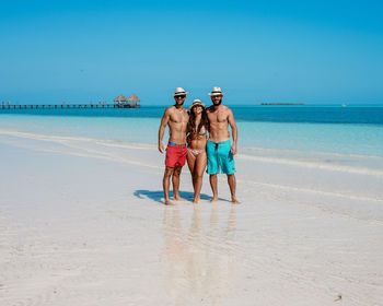 Boys on beach against sky