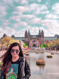 Portrait of smiling young woman with building in background