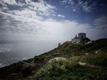 Scenic view of sea by buildings against sky