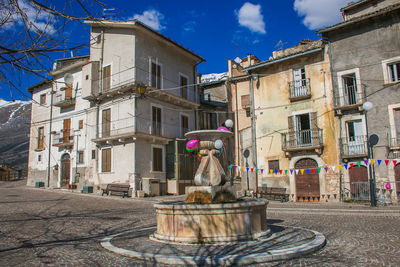 Statue by street against buildings in city