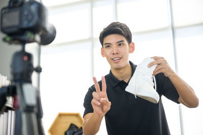 Portrait of young man holding camera