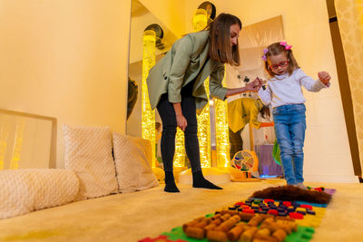 Therapist helping a child living with cerebral palsy improve her walking ability. texture walk.