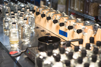 Bottles of liquor sitting on a stand after getting a wax seal.