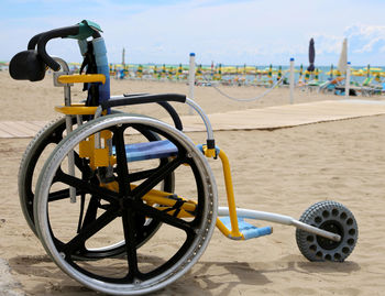 Special wheelchair with aluminum wheels to move on the sand of the beach