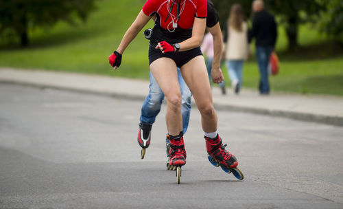 Low section of women walking on road