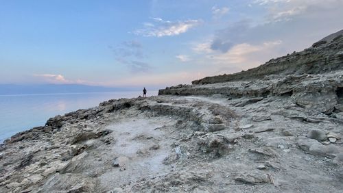 Rock formations on shore against sky