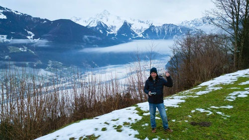 Rear view of man walking on snow covered mountain