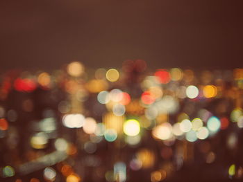 Defocused image of illuminated lights in city at night