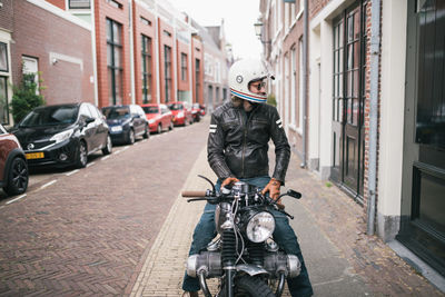 Person riding motorcycle on street in city