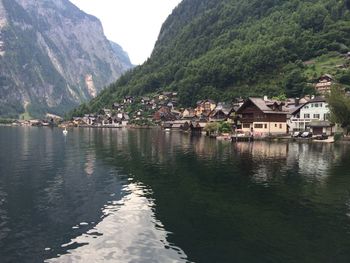 Houses by river against mountains