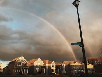 Rainbow over buildings in city against sky