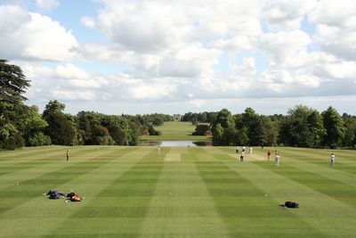 Scenic view of cricket course against sky