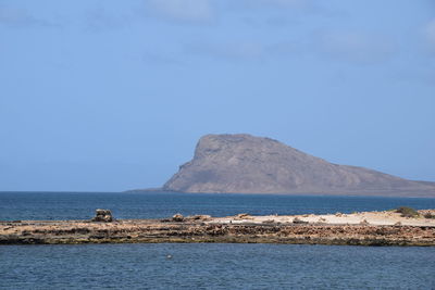 Scenic view of sea and mountains against sky