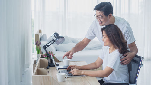 Side view of young couple standing on table