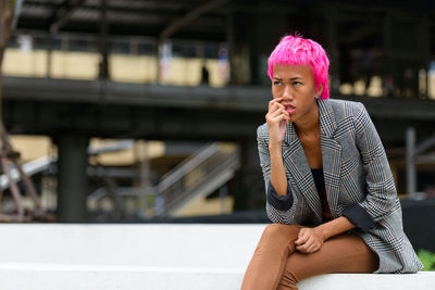 Portrait of young woman sitting outdoors