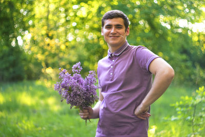 Young man standing against plants