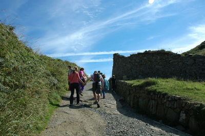 People walking on mountain against sky