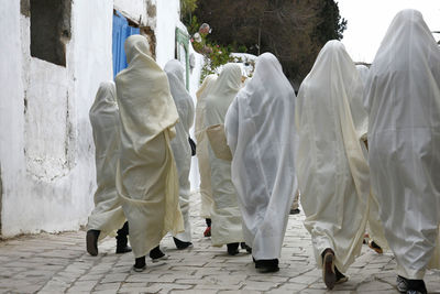 Rear view of people walking on footpath