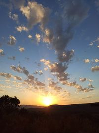 Scenic view of silhouette field against sky at sunset