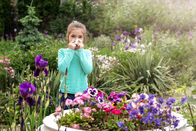 Allergy. a girl covers her nose with a napkin from an allergic reaction to blooming flowers 
