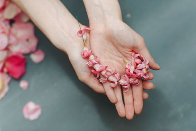 Cropped hand holding flowers over table