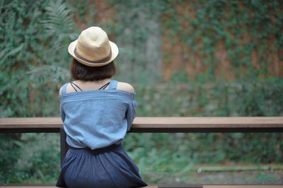 Rear view of woman standing by railing