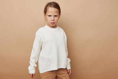 Portrait of boy standing against yellow background