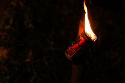 Close-up of lit candles on field at night