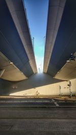 Man on bridge in city against sky