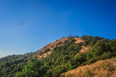 Low angle view of mountain against clear blue sky