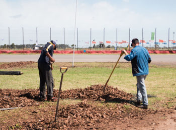 Full length of men working on field