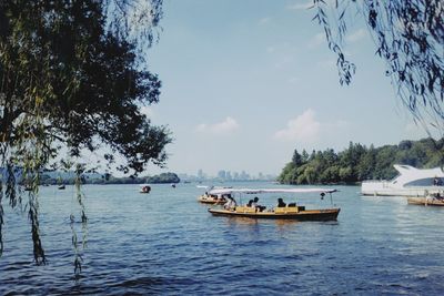 Sailboats moored on sea against sky