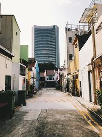 Alley amidst buildings in city against clear sky