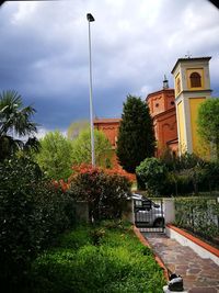 Street amidst trees and plants against sky