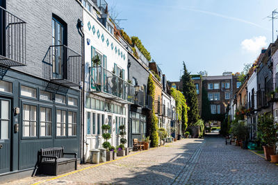 Empty road amidst buildings against sky