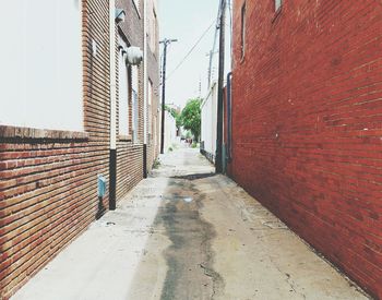 Footpath amidst houses against sky in city