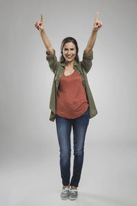 Portrait of smiling young woman standing against white background