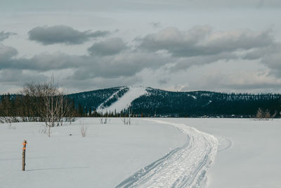 Panoramic view of snow covered field against sky