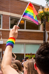 People with multi colored flags against built structure