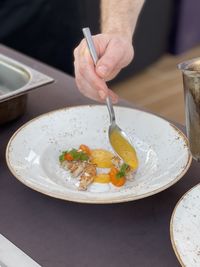 Cropped hand of person preparing food on table