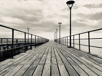 View of pier on sea against cloudy sky