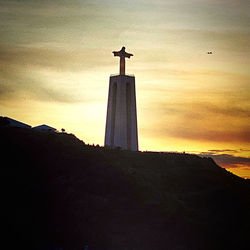 Low angle view of silhouette statue against sky during sunset