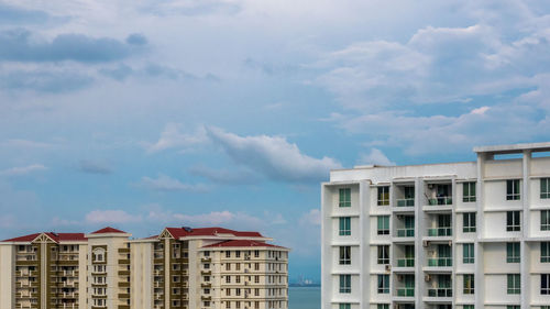 Low angle view of buildings against cloudy sky
