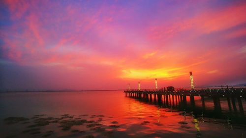 Scenic view of sea against cloudy sky during sunset