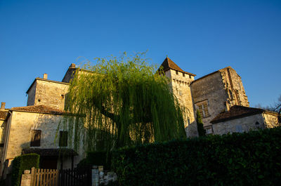 Low angle view of old building against clear blue sky