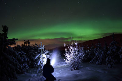 Full length of a man on snow covered landscape at night