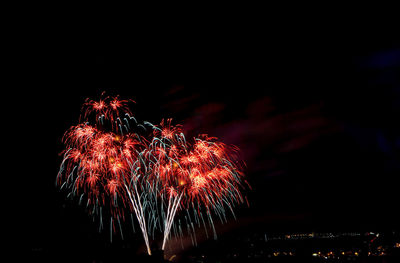 Low angle view of firework display at night