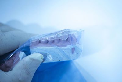 Cropped hand of dentist holding dentures